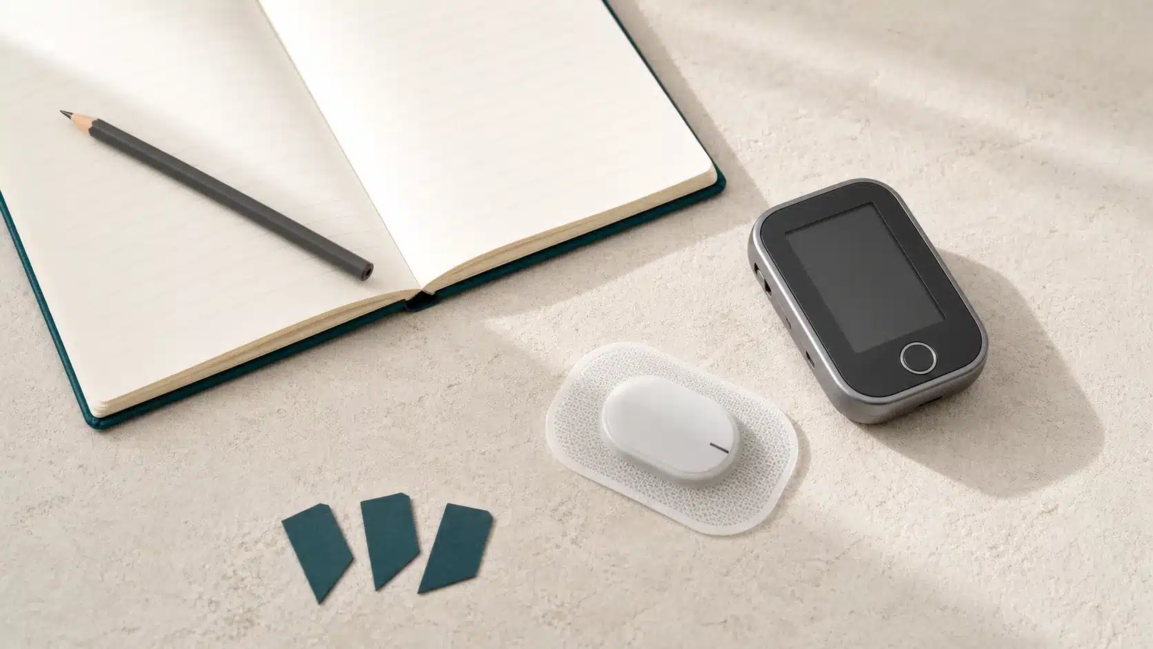 Wearable heart-rhythm monitor, symptom diary, and recording device on a pale surface